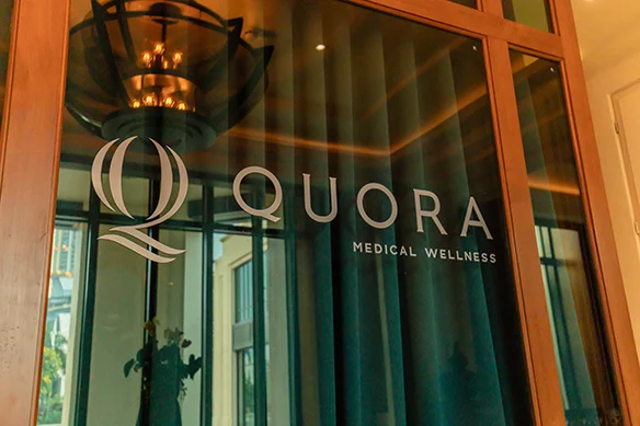 The illuminated Quora Medical Wellness wordmark in the clinic reception